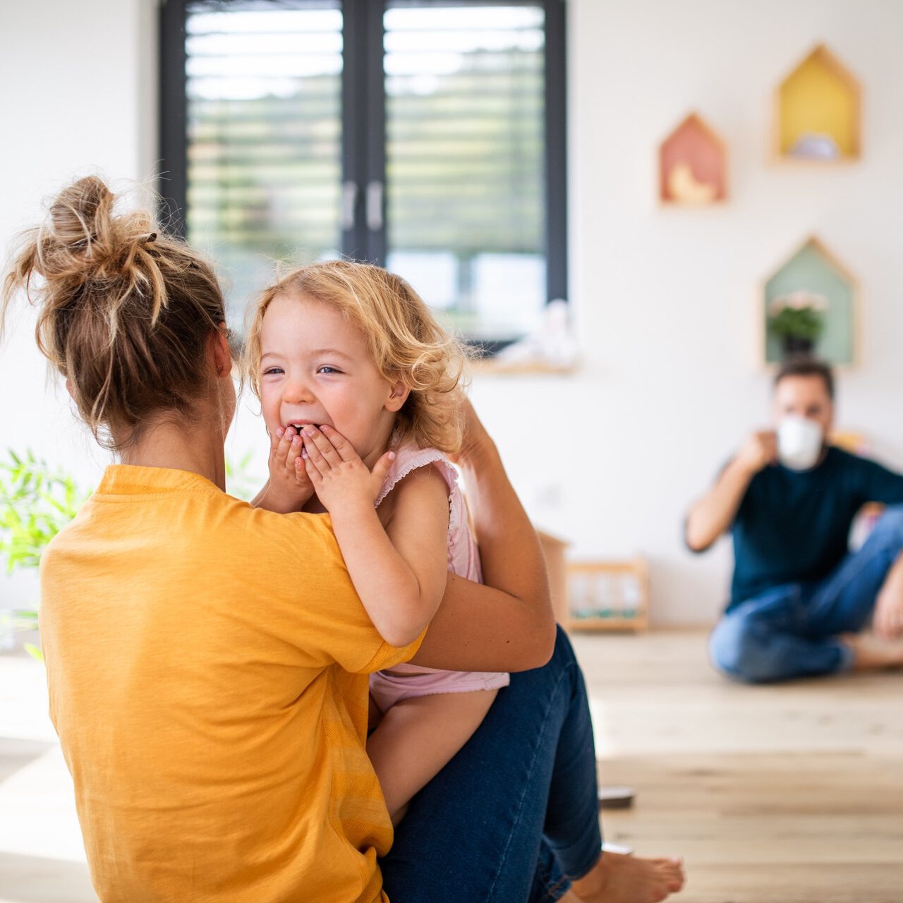 Jeune famille avec deux petits enfants à l'intérieur dans la chambre, s'amusant.